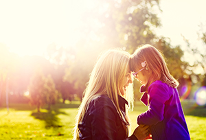 A mother and daughter with their foreheads together