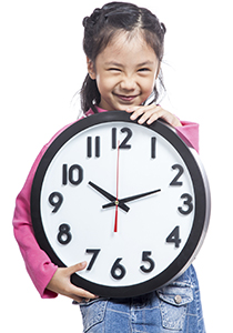 Asian little girl hold a clock and laughing isolated on white background