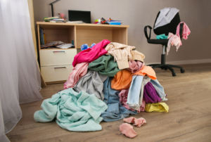 A pile of unfolded clothes in disarray on the floor. Floordrobe.