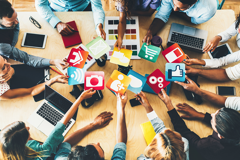 Business people holding icons at a meeting.